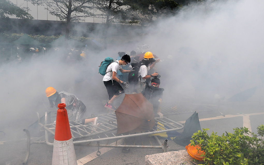 Manifestantes en una nube de gas lacrimógeno cerca del Consejo Legislativo en Hong Kong / Foto: AP. 