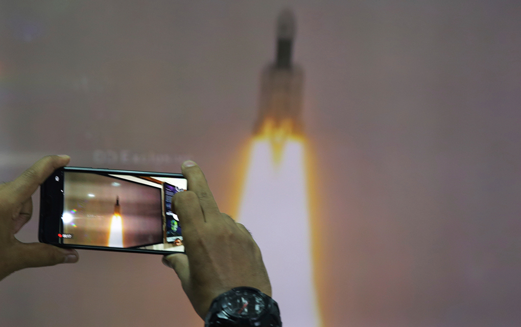 Un hombre en el Planetario Nehru de Nueva Delhi toma fotos de la transmisión por internet del despegue del vehículo de lanzamiento satelital Geosynchronous de la Organización de Investigación Espacial India en el centro espacial Satish Dhawan en India / Foto: AP. 