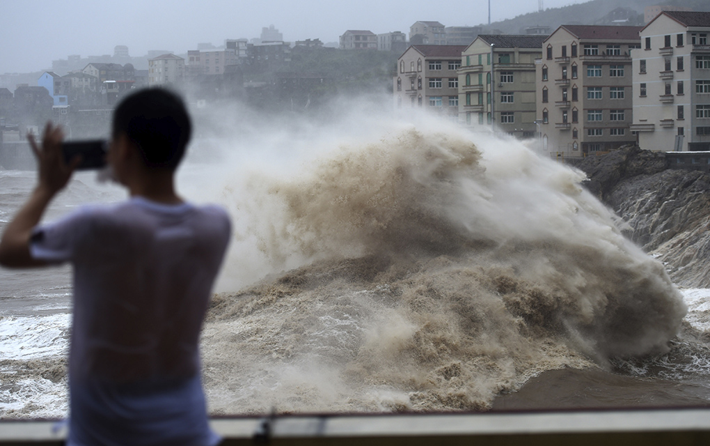 Un hombre graba con su celular el fuerte oleaje causado por la cercanía del tifón Lekima, en la ciudad de Wenling, en el la provincia oriental china de Zhejiang / Foto: AP