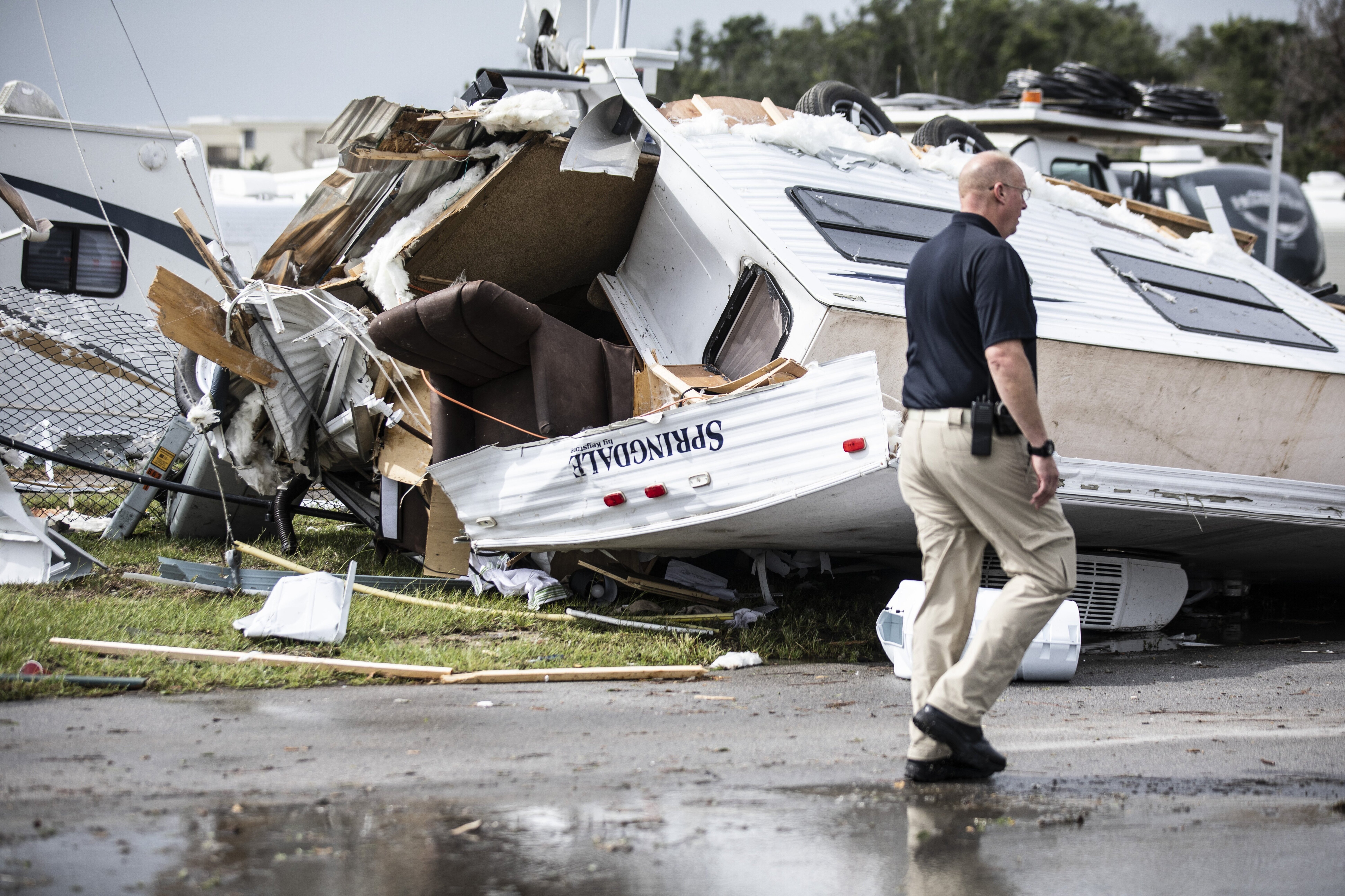 Oficial de la policía de la isla Emerald, camina junto a un lote de casas remolque dañadas por el huracán /AP