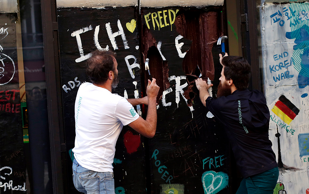 El chocolatero francés Patrick Roger, izquierda, y su asistente creativo Angelo Dao destruyen una réplica hecha de chocolate del Muro de Berlín / AP 