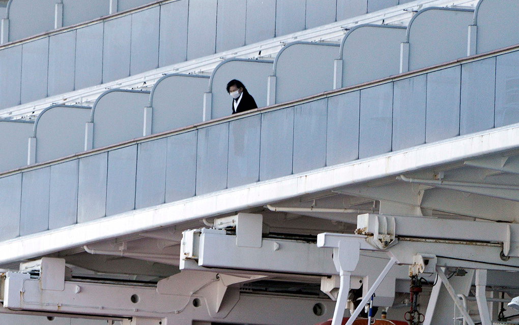 Un pasajero sale al balcón del buque crucero Diamond Princess anclado en el puerto de Yokohama, Japón / AP