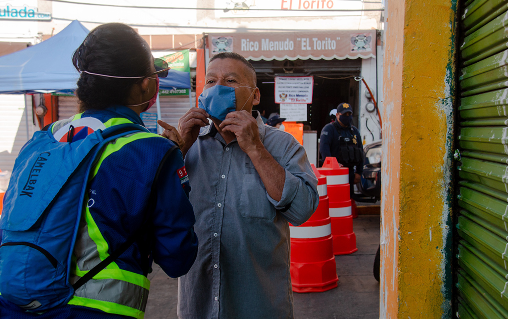 Personal de Protección Civil instalado en tianguis y mercados enseña a los ciudadanos a colocarse el tapabocas. Foto Selene Ugalde