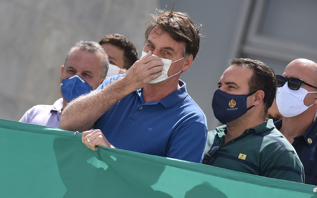 La fotografía de archivo del 17 de mayo de 2020 muestra al presidente Jair Bolsonaro tocándose su mascarilla para protegerse del coronavirus durante una protesta contra el Supremo Tribunal Federal y el Congreso Nacional, en Brasilia, Brasil. / Foto: AP