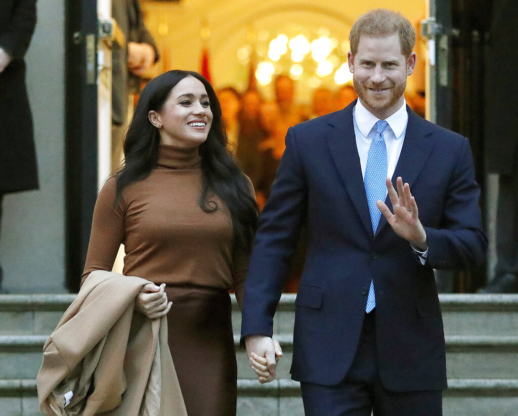 El príncipe Enrique de Inglaterra y Meghan, duquesa de Sussex, salen del Canada House en Londres. (AP)