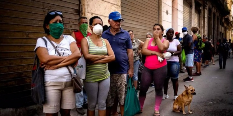 Cubanos esperan en línea por una ración de comida durante la pandemia. AP