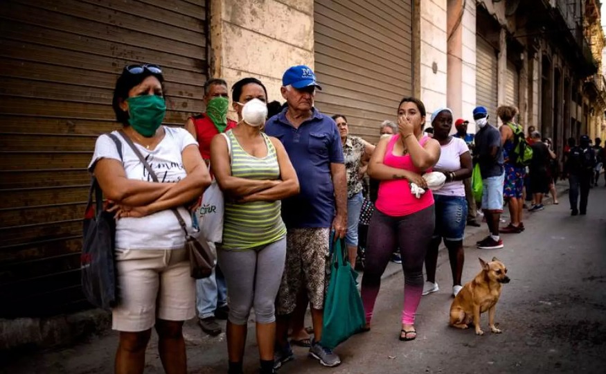 Cubanos esperan en línea por una ración de comida durante la pandemia. AP