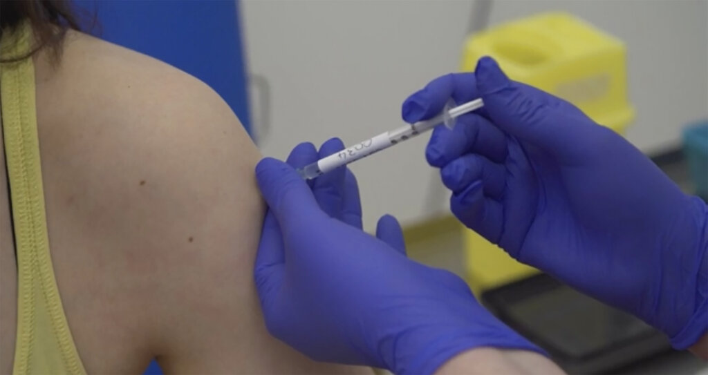 En Oxford, una persona recibe una inyección en una de las pruebas iniciales con seres humanos de una posible vacuna contra el COVID-19. (AP)