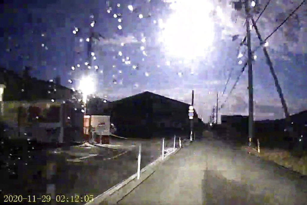 Esta imagen tomada de una grabación de la carretera muestra un brillante meteorito, en la parte superior central, sobre una calle en la prefectura de Tokushima, en el suroeste de Japón, el domingo 29 de noviembre de 2020. (AP)