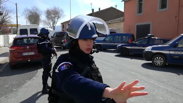 Policía francesa busca hacerse paso entre un fotógrafo durante la intervención a un secuestro. AP