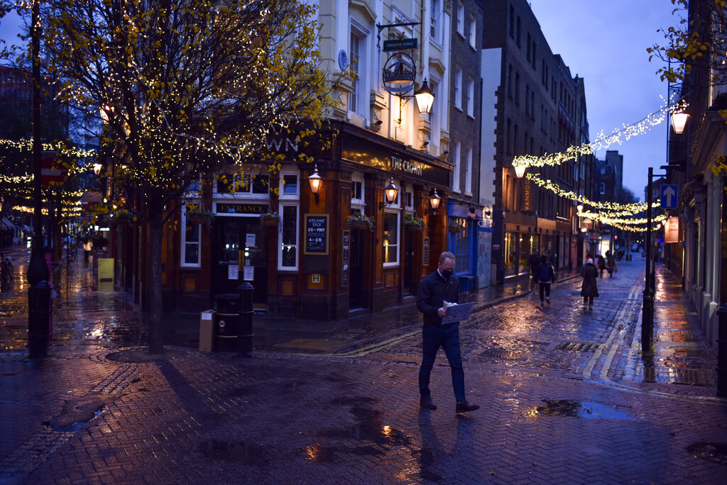 Un hombre con mascarilla camina frente a un pub cerrado en la zona Seven Dials de Covent Garden, en Londres.