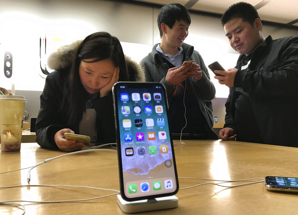 En esta imagen de archivo del lunes 6 de noviembre de 2017, compradores mirando celulares en una tienda de Beijing, China. (AP)