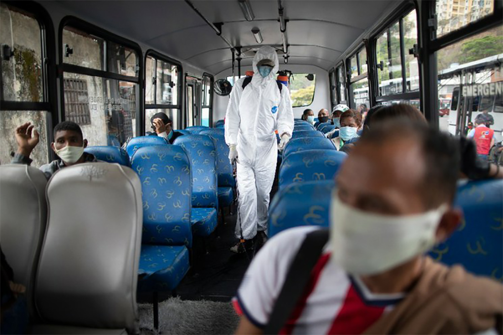 Trabajador del servicio de transporte público sanitiza un autobús en Caracas. (AP)
