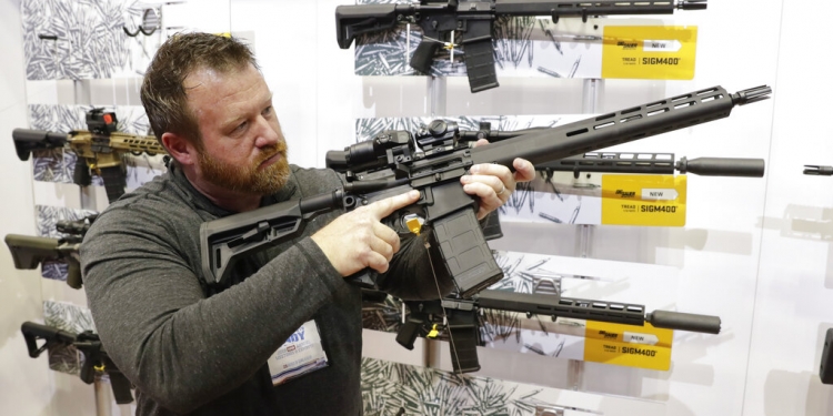 Bryan Oberc, de Munster, Indiana, examina un fusil AR-15 en la sala de exhibiciones de la reunión anual de la Asociación Nacional del Rifle en Indianapolis el 27 de abril del 2019. (AP)