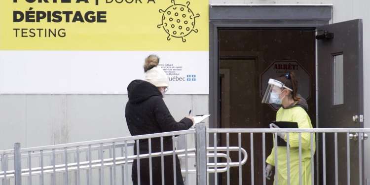 Una empleada de salud recibe a una mujer que va a realizarse la prueba del coronavirus en una clínica en Montreal, Canadá, el 6 de diciembre de 2020. (AP)