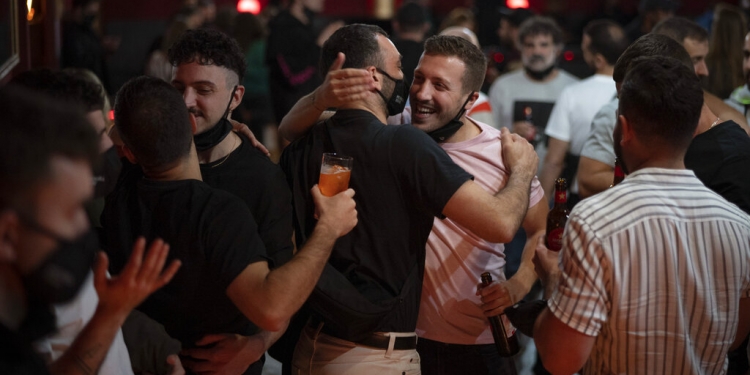 Unas personas se saludan antes de un concierto en Barcelona, España, el 12 de diciembre de 2020. (AP)