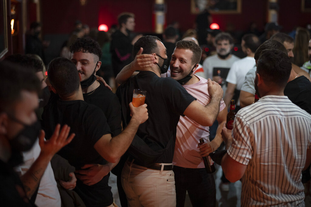 Unas personas se saludan antes de un concierto en Barcelona, España, el 12 de diciembre de 2020. (AP)