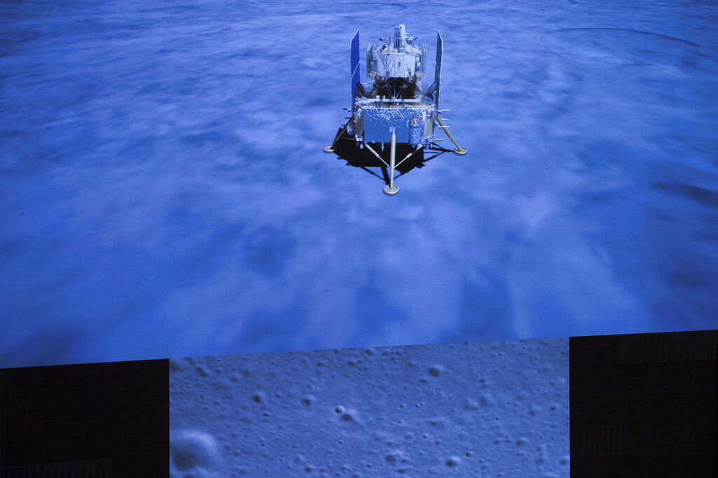 Una pantalla muestra una foto de la superficie lunar (abajo) y a la nave espacial Ceng'e-5 tras alunizar, en el Centro de Control Aeroespacial de Beijing. (Jin Liwang/Xinhua vía AP)