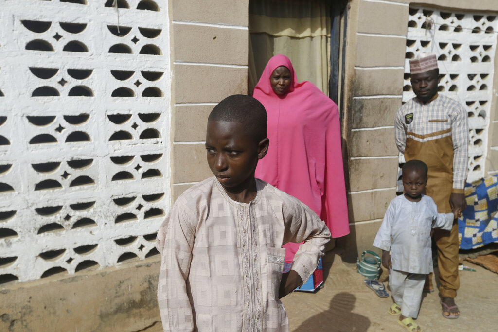 Usman Mohammad Rabiu, de 13 años, su madre Asmau Hassan y sus hermanos en su casa en Ketare, Nigeria, el 19 de diciembre del 2020. (AP)