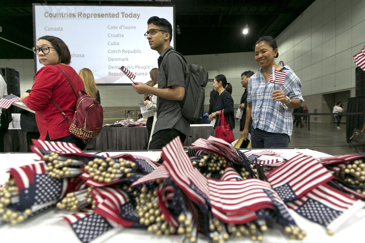 Postulantes a la ciudadanía americana toman sus banderitas y se preparan para hacer el juramento. AP