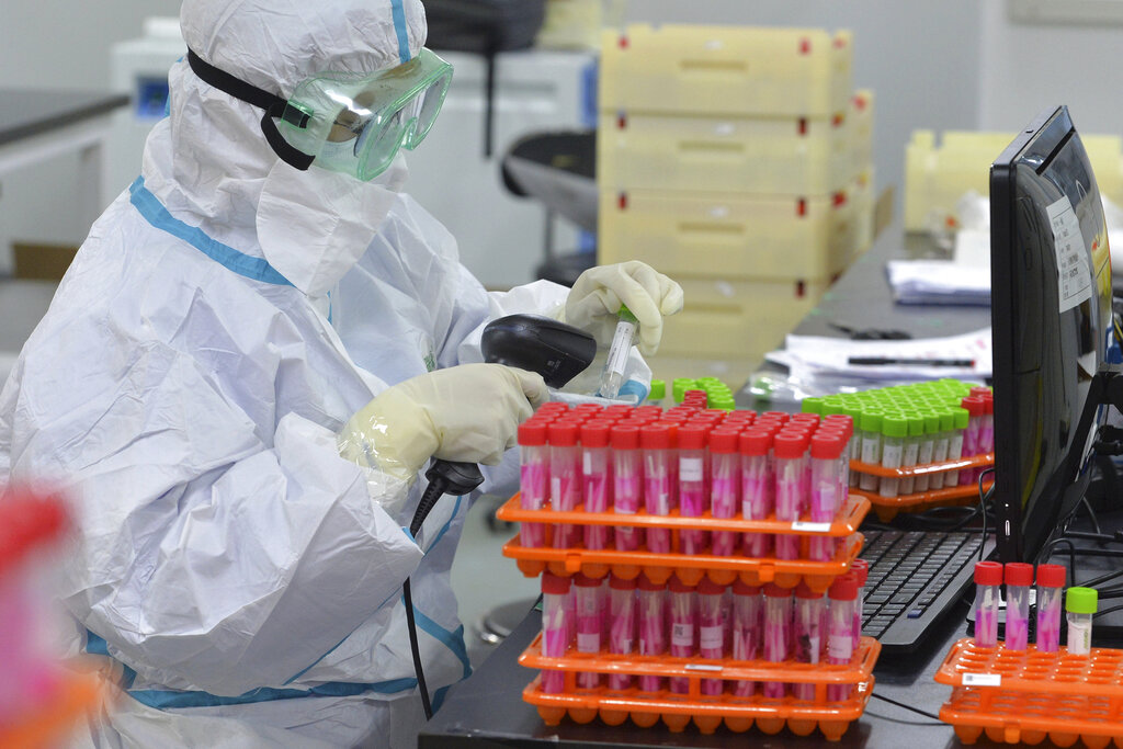 Un trabajador sanitario escanea muestras de ácido nucleico reunidas para una campaña masiva de pruebas diagnósticas de coronavirus, en un laboratorio en el municipio de Tianjin, en el norte de China, el lunes 23 de noviembre de 2020. (Chinatopix via AP)