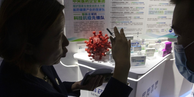 Una promotora habla sobre la vacuna contra el COVID-19 producida por la subsidiaria de Sinopharm, CNBG, durante una feria comercial en Beijing, el domingo 6 de septiembre de 2020. (AP)