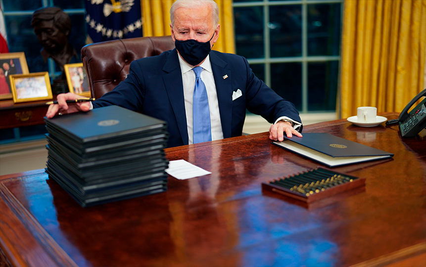 El presidente Joe Biden firma decretos el día de su investidura durante sus primeros minutos en el Despacho Oval de la Casa Blanca