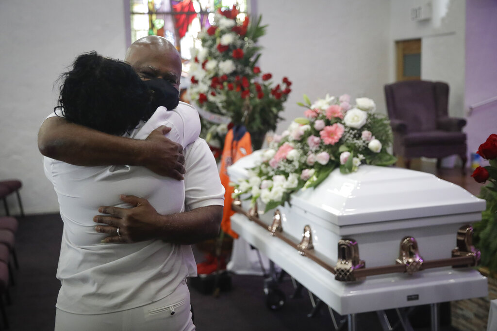 En esta fotografía de archivo del 21 de julio de 2020, Darryl Hutchinson, de frente, recibe el abrazo de un pariente durante el funeral de Lydia Nunez, prima del primero, en la Iglesia Bautista Metropolitana en Los Ángeles. Lydia Nunez falleció de COVID-19. (AP)