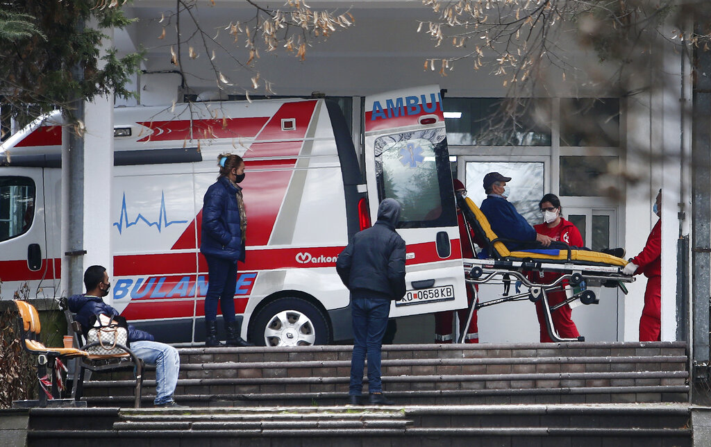 Personal de la Clínica Universitaria de Skopie, Macedonia del Norte, baja a un paciente de una ambulancia el 29 de diciembre del 2020. Los países de los Balcanes occidentales todavía no han redibido vacunas para el COVID-19. (AP)