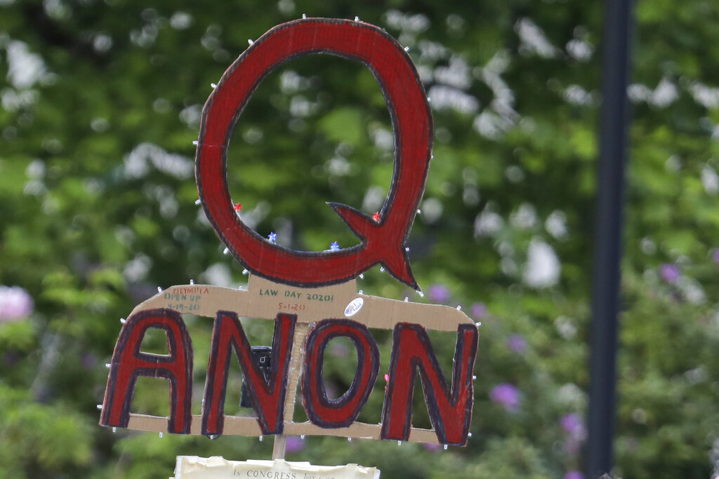 Una persona con un cartel de QAnon en una protesta en Olympia, Washington, el 14 de mayo del 2020. (AP)