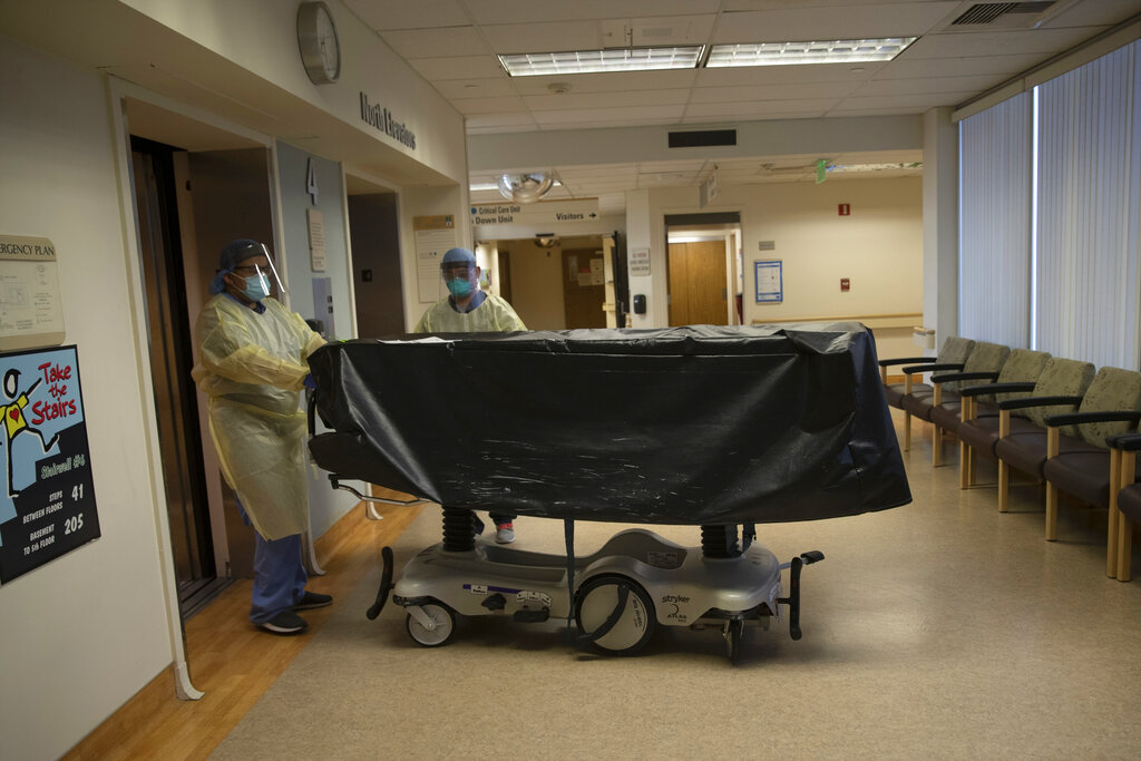 En esta fotografía del 7 de julio de 2020, personal ingresa en un elevador con el cadáver de una víctima de COVID-19 en un carrito en el Centro Médico St. Jude en Fullerton, California. (AP)