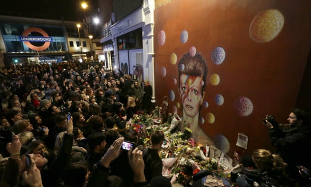 Fanáticos del rockero británico celebran su memoria con flores frente a un mural en el sur de Londres. AP