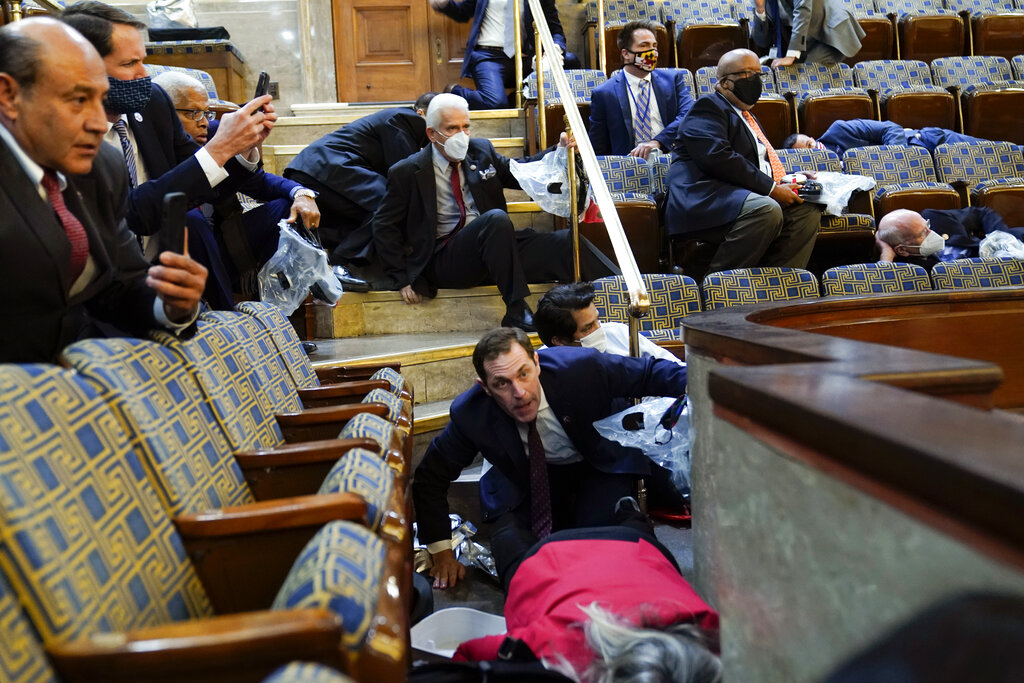 Legisladores se refugian ayer en la galería de la Cámara de Representantes. (AP)