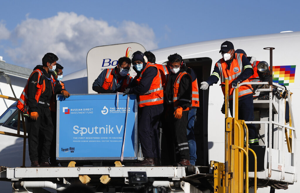 Los empleados del aeropuerto descargan el primer envío de la vacuna rusa Sputnik V contra COVID-19 después de que arribó al aeropuerto internacional de El Alto, en Bolivia, el jueves 28 de enero de 2021. (AP)