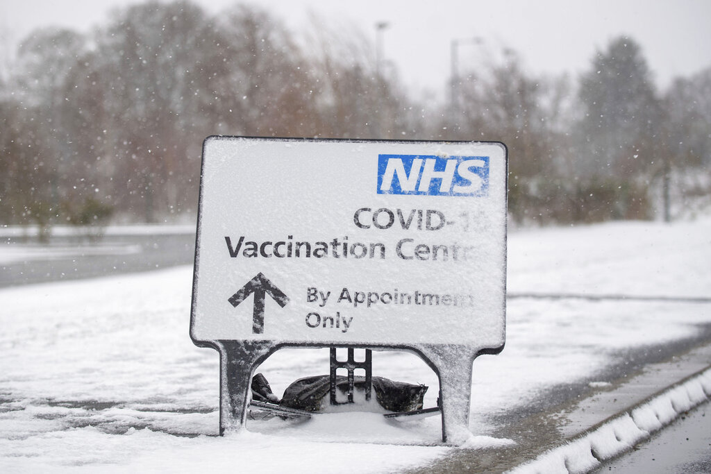 Un letrero cubierto de nieve dirige a las personas al centro de vacunación contra el COVID-19 en el estadio comunitario Jobserve en Colchester, Inglaterra, el domingo 7 de febrero de 2021. (Joe Giddens/PA vía AP)