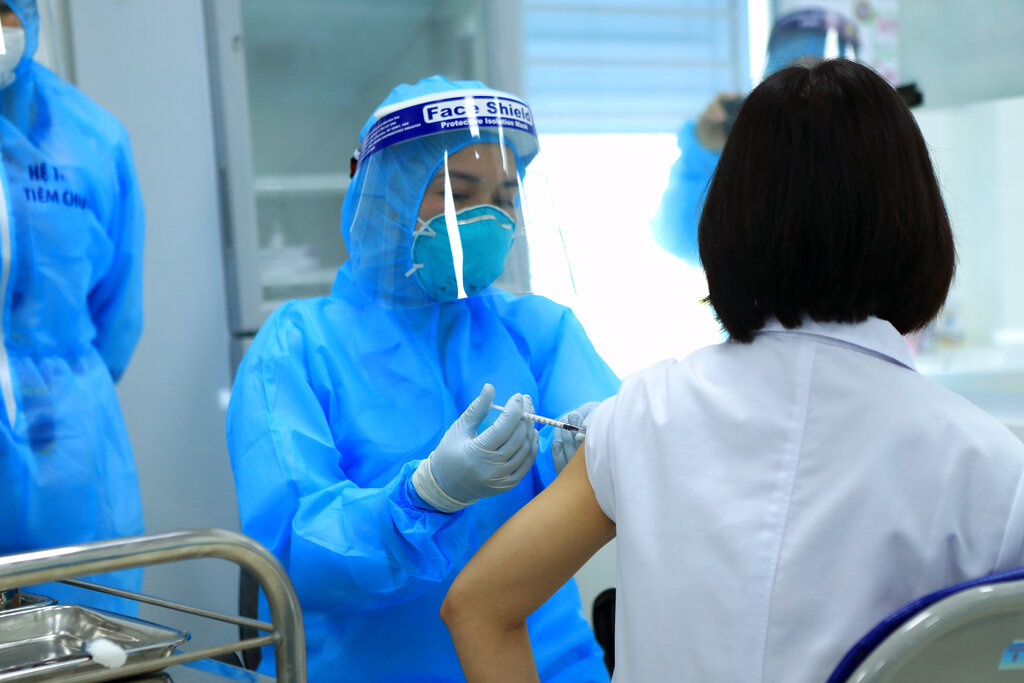 Personal médico aplica una doctora la vacuna de coronavirus de AstraZeneca, en el Hospital de Enfermedades Tropicales, en Hanoi, Vietnam, el 8 de marzo de 2021. (AP Foto/Hau Dinh)