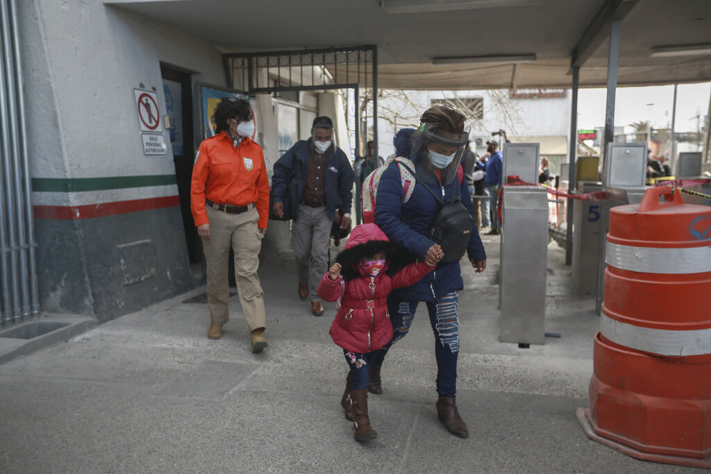 Una familia de migrantes cruza la frontera entre México y Estados Unidos el viernes 26 de febrero de 2021 para ingresar a El Paso, Texas, en Ciudad Juárez, México. (AP Foto/Christian Chávez)