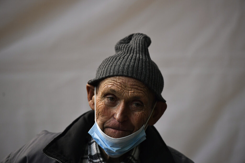 Joaquín Martínez, de 81 años, espera 15 minutos después de recibir la segunda dosis de la vacuna de Pfizer durante una campaña de vacunación en el pueblo de Navarrete, en el norte de España, el 19 de marzo de 2021. (AP Foto/Álvaro Barrientos)