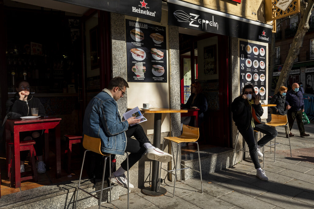 Unas personas desayunan en un restaurante cerca del mercado el Rastro, en Madrid, España, el 14 de febrero de 2021. (AP Foto/Bernat Armangue)
