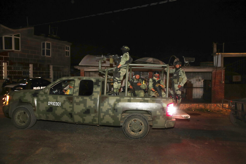 Soldados fuertemente armados ingresan al área donde 13 policías fueron emboscados y asesinados por presuntos narcotraficantes el jueves 18 de marzo de 2021, en Coatepec Harinas, Estado de México. (AP Foto/Marco Ugarte)