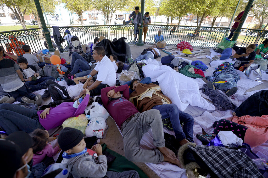 Un grupo de migrantes deportados por EEUU descansa en una glorieta de Reynosa, México, a la que fueron enviados por las autoridades mexicanas el 20 de marzo del 2021. (AP Photo/Julio Cortez)