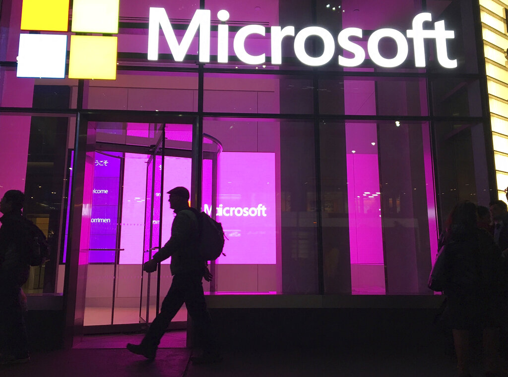 ARCHIVO - En esta fotografía del 10 de noviembre de 2016 un hombre camina frente a una oficina de Microsoft en Nueva York. (AP Foto/Swayne B. Hall, Archivo)
