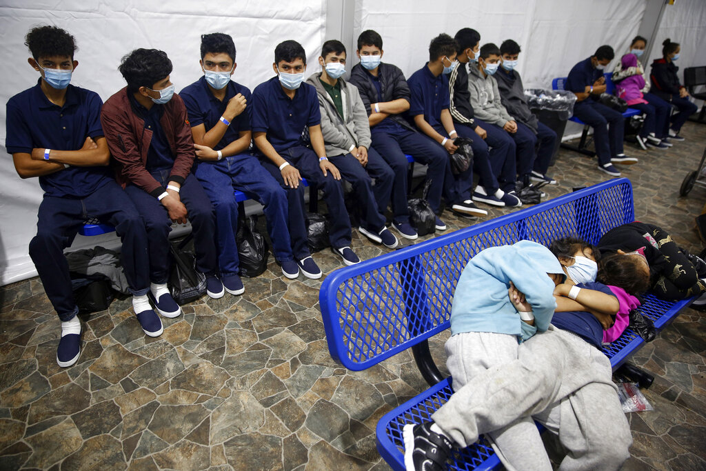 ARCHIVO - En esta fotografía del 30 de marzo de 2021, varios adolescentes y niños migrantes esperan su turno en un sitio de procesamiento dentro de un centro de detención de la Oficina de Aduanas y Protección Fronteriza, en Donna, Texas. (AP Foto/Darío López-Mills, Pool, archivo)