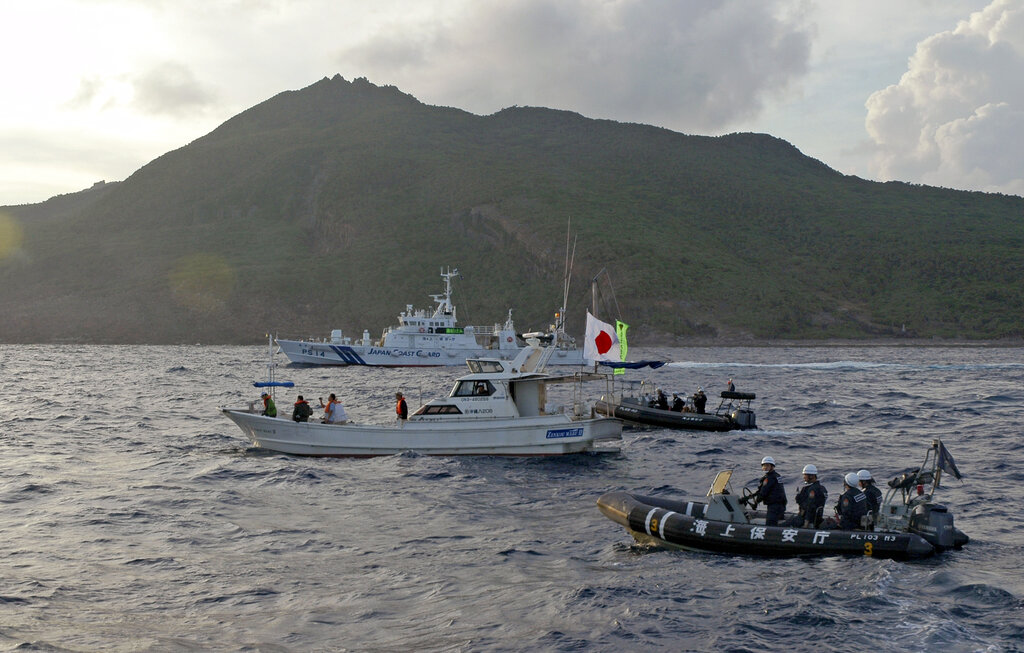 Un barco de la Guardia Costera de Japón navega cerca de otros barcos advirtiendo que se alejen de un grupo de islas en disputa por Japón y China, el 18 de agosto de 2013. (Foto AP/Emily Wang, archivo)