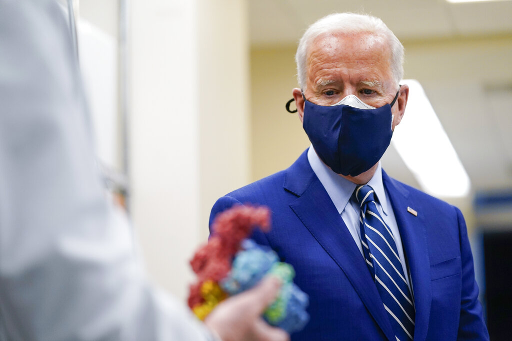 ARCHIVO - En esta imagen del 11 de febrero de 2021, el presidente de Estados Unidos, Joe Biden, mira a un modelo del COVID-19 durante una visita al Laboratorio Viral de Patogénesis en lso Institutos Nacionales de Salud en Bethesda, Maryland, EE.UU. (AP Foto/Evan Vucci, Archivo)