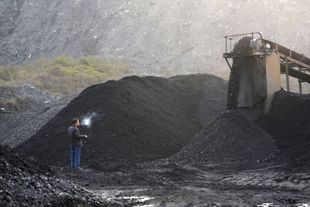 Un trabajador, junto a una máquina empleada para retirar carbón en una mina en Huaibei, en la provincia de Anhui, en el centro de China, el 3 de noviembre de 2016. (Chinatopix vía AP)