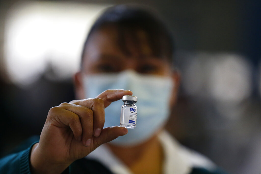 En esta imagen del 24 de febrero de 2021, una empleada de salud sostiene una ampolleta de la vacuna Sputnik V contra el coronavirus, durante la campaña de vacunación de la secretaría de Salud para mexicanos mayores de 60 años, en la Ciudad de México. (AP Foto/Rebecca Blackwell, Archivo)
