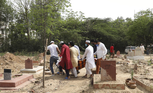 Varias personas cargan el cadáver de una víctima de COVID-19 el lunes 5 de abril de 2021 para su entierro en un cementerio de Nueva Delhi, India. (AP Foto/Manish Swarup)