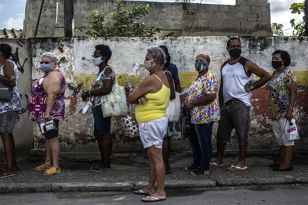 People over 71 and their relatives stand in line for COVID-19 vaccinations in Belford Roxo, Brazil, on Wednesday, March 31, 2021. A variant first found in the country has appeared in North America. Declining infection rates overall masked a rise in more contagious forms of the coronavirus which vaccines can stop the spread, if Americans postpone celebration just a bit longer. (Dado Galdieri/The New York Times)