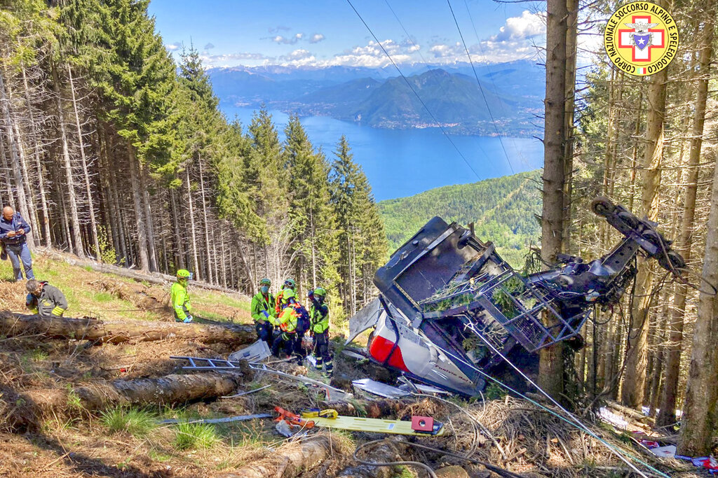 Rescatistas trabajan entre los restos de un teleférico accidentado cerca de la cima de la línea Stresa-Mottarone en la región del Piamonte, en el norte de Italia, el domingo 23 de mayo de 2021. (Servicio de Socorro Alpino y Espeolológico del Piamonte via AP)